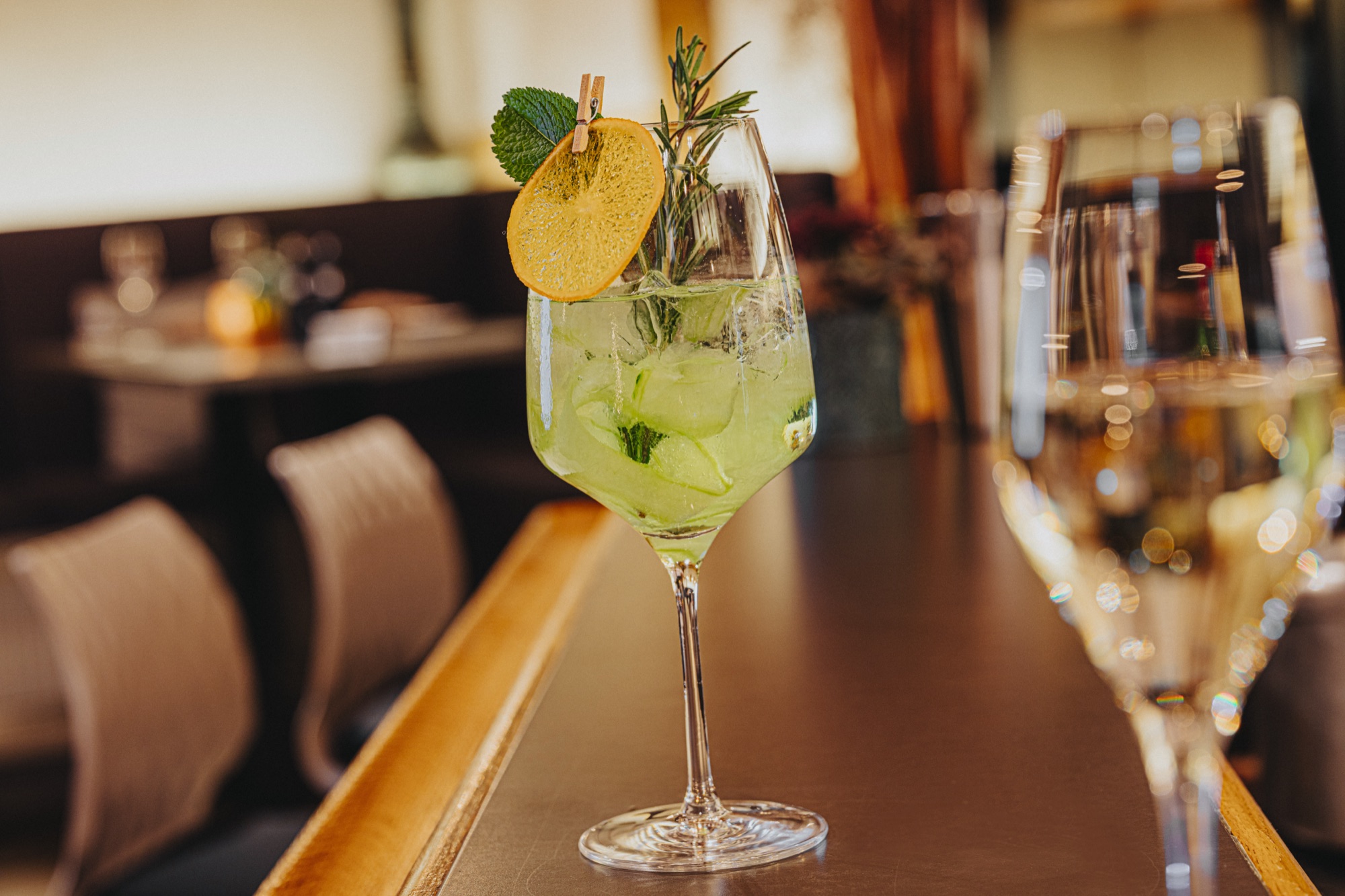 Grüner Drink mit Zitrusgarnitur auf dem Tresen der KOSTBAR im FESTLAND